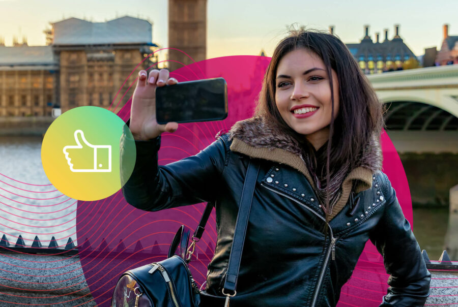 A woman films a video on a smartphone in London