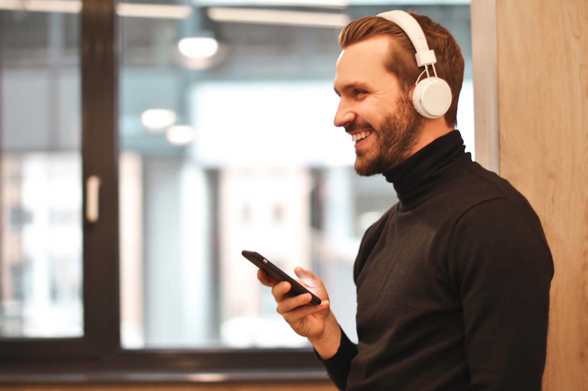 Man listens to Clubhouse App on smartphone