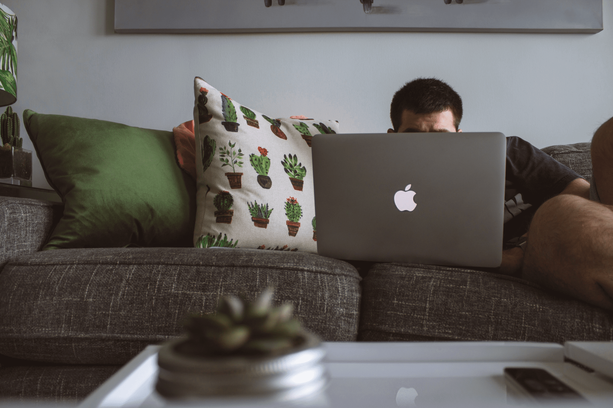 man on couch watching laptop to get more views on youtube