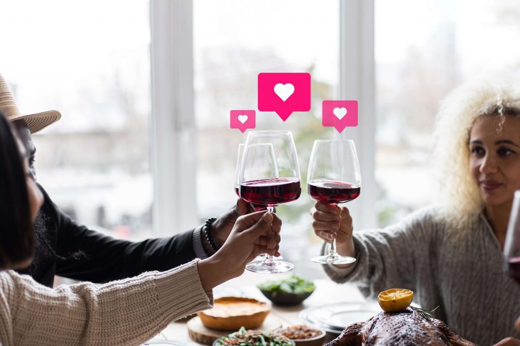 people clinking wine glasses with social hearts