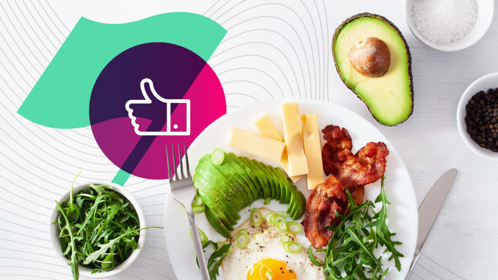 a white plate with cheese, meat, egg, greens, and an avocado on the side