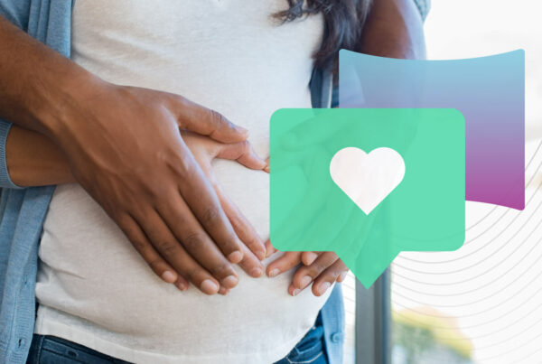 A BIPOC couple with hands on a pregnant person's stomach