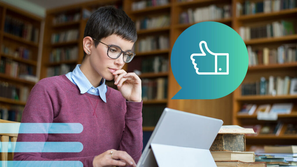 A history influencer with short hair and glasses looks at a laptop in a library.