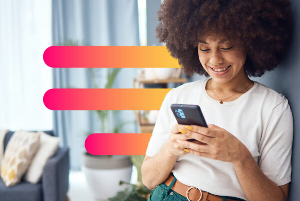 A woman looks at her cellphone and smiles; IZEA announced today that its Managed Services team secured contract bookings totaling $7.9 million in the fourth quarter of 2022.