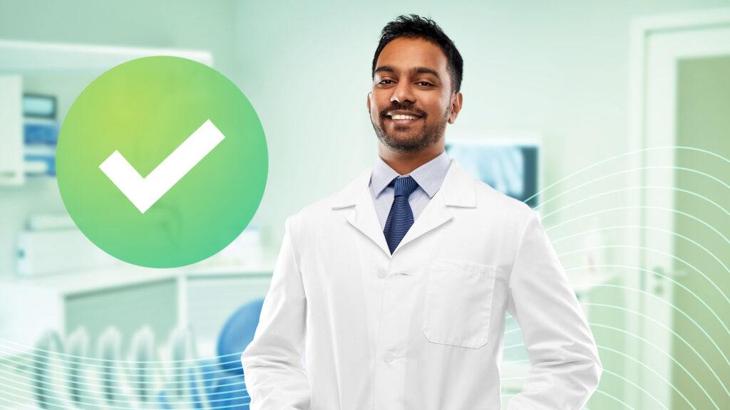 A top dentist influencer standing in his office smiling.