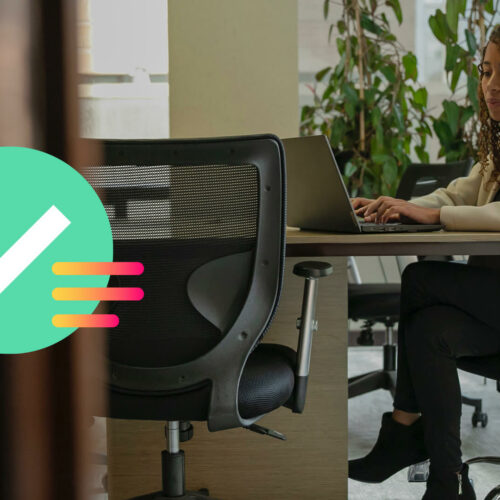 A marketer sits at a desk and types on a laptop