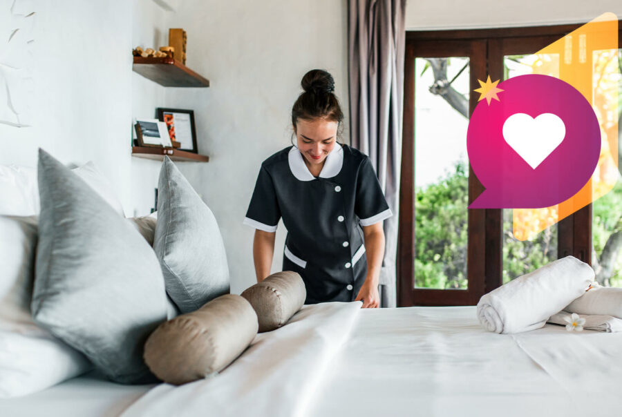A housekeeper makes a hotel bed