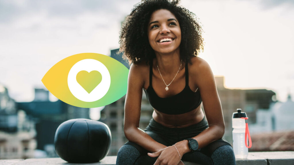 A woman sits next to a water bottle with a city view in the backgroun