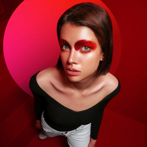 A woman with red eye makeup and a black top