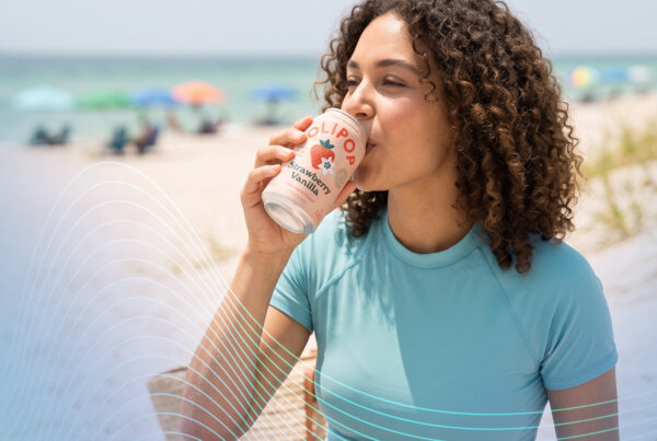 Woman at beach drinking a soda