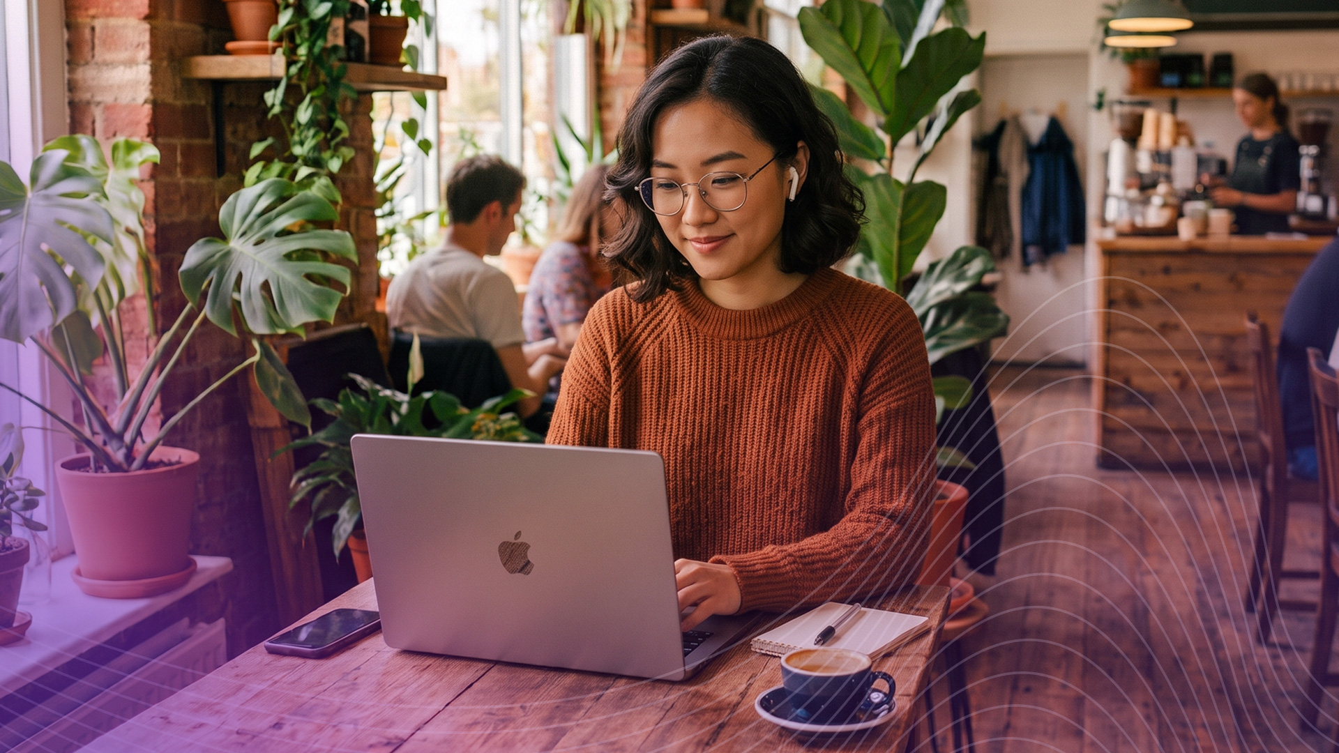 woman at cafe typing on her Apple Macbook laptop